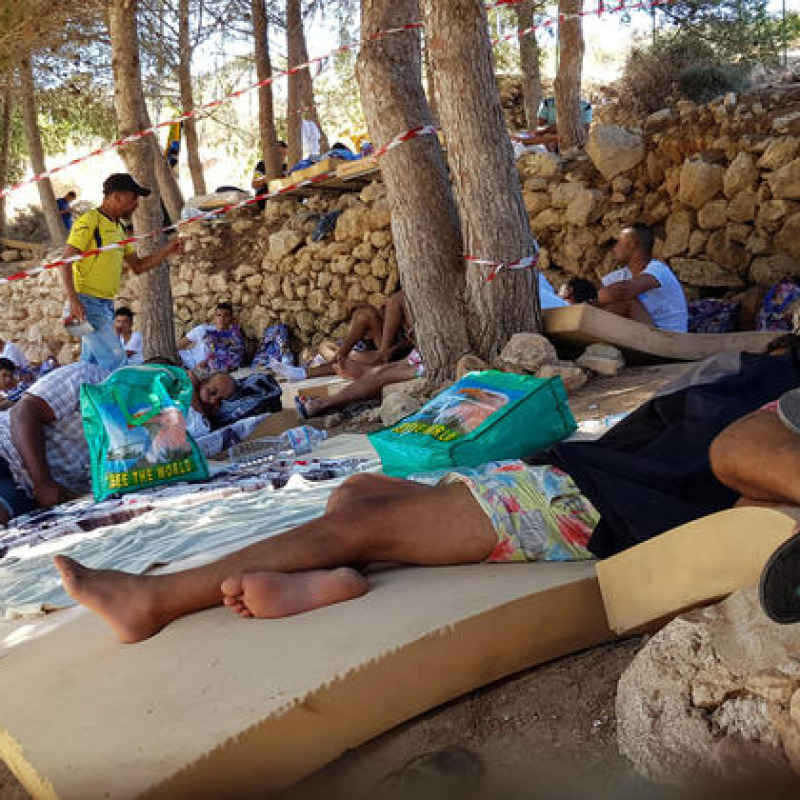 Migranti dormono a terra all'interno dell'hotspot di contrada Imbriacola