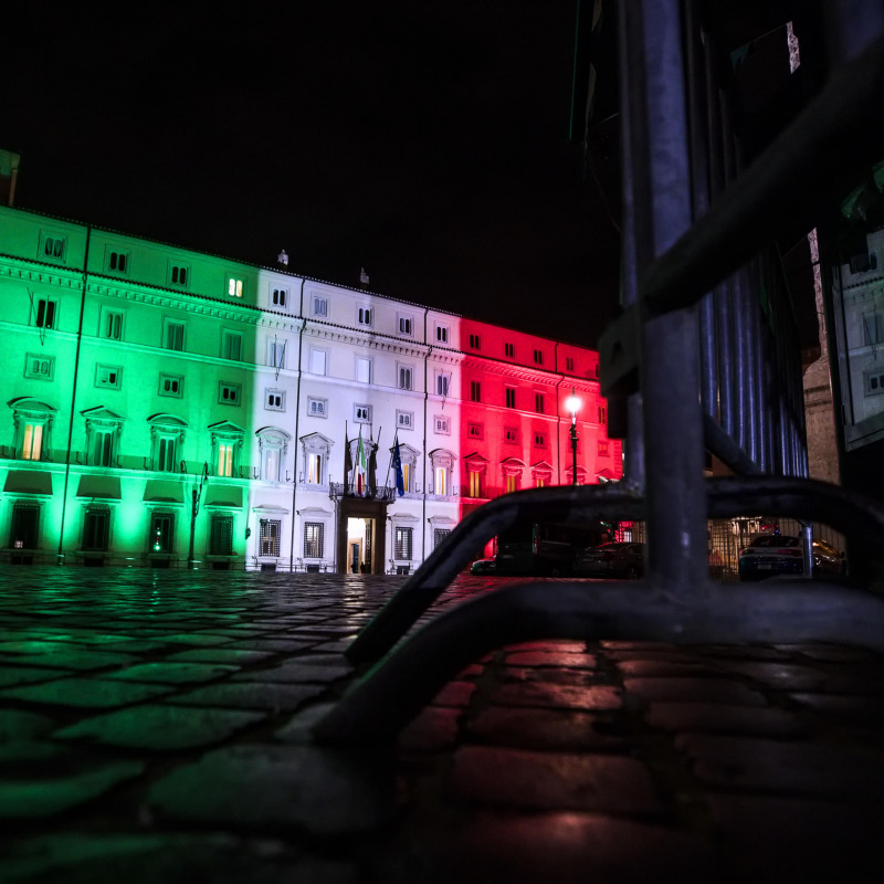L'esterno di palazzo Chigi illuminato dal tricolore