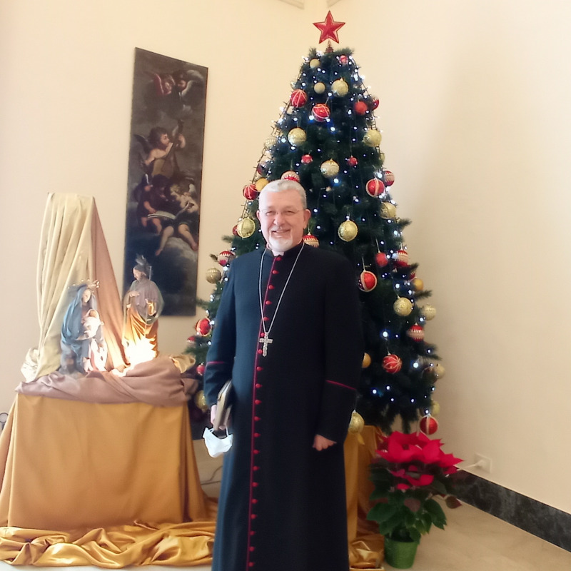 Monsignor Alessandro Damiano accanto al sobrio presepe e all’albero di Natale nel palazzo vescovile