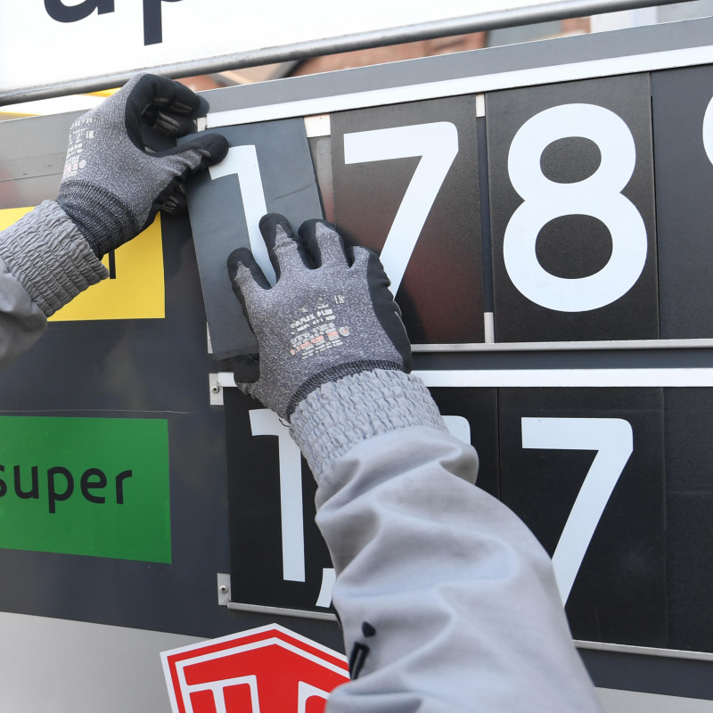 Un addetto di un distributore di benzina aggiorna il prezzo del carburante