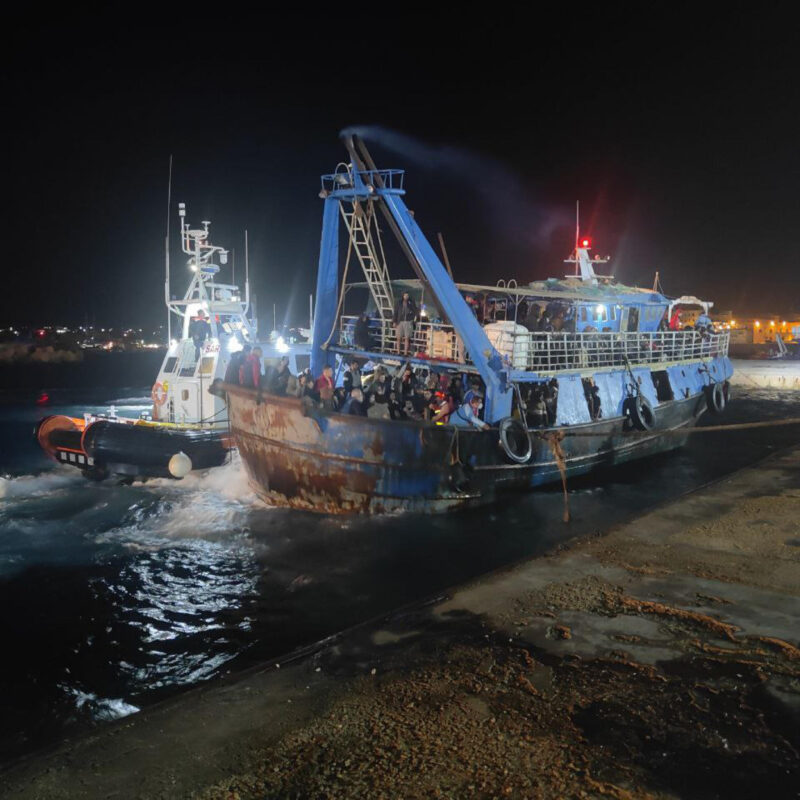 Un peschereccio con a bordo i 576 migranti attracca al molo commerciale di Lampedusa (foto di Elio Desiderio/Ansa)